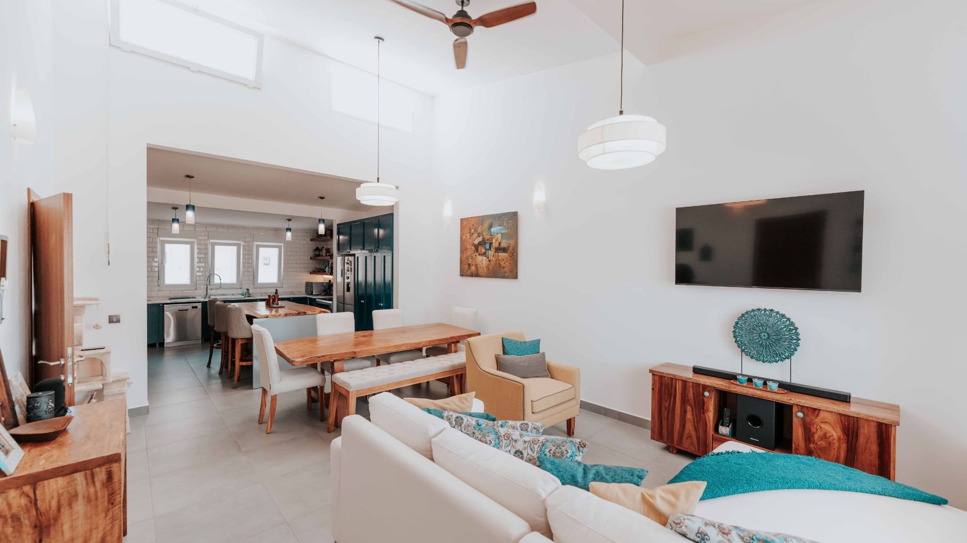 Modern open-concept living space with white and teal color palette